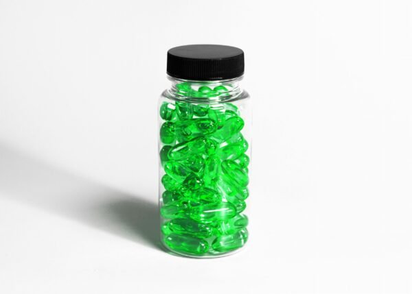 glass medication bottle with green colored gel pills
