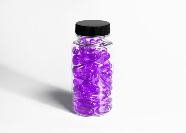 glass medication bottle with purple colored gel pills