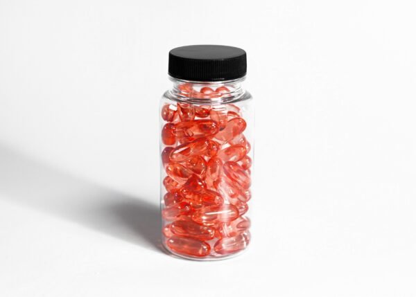 glass medication bottle with purple colored gel pills